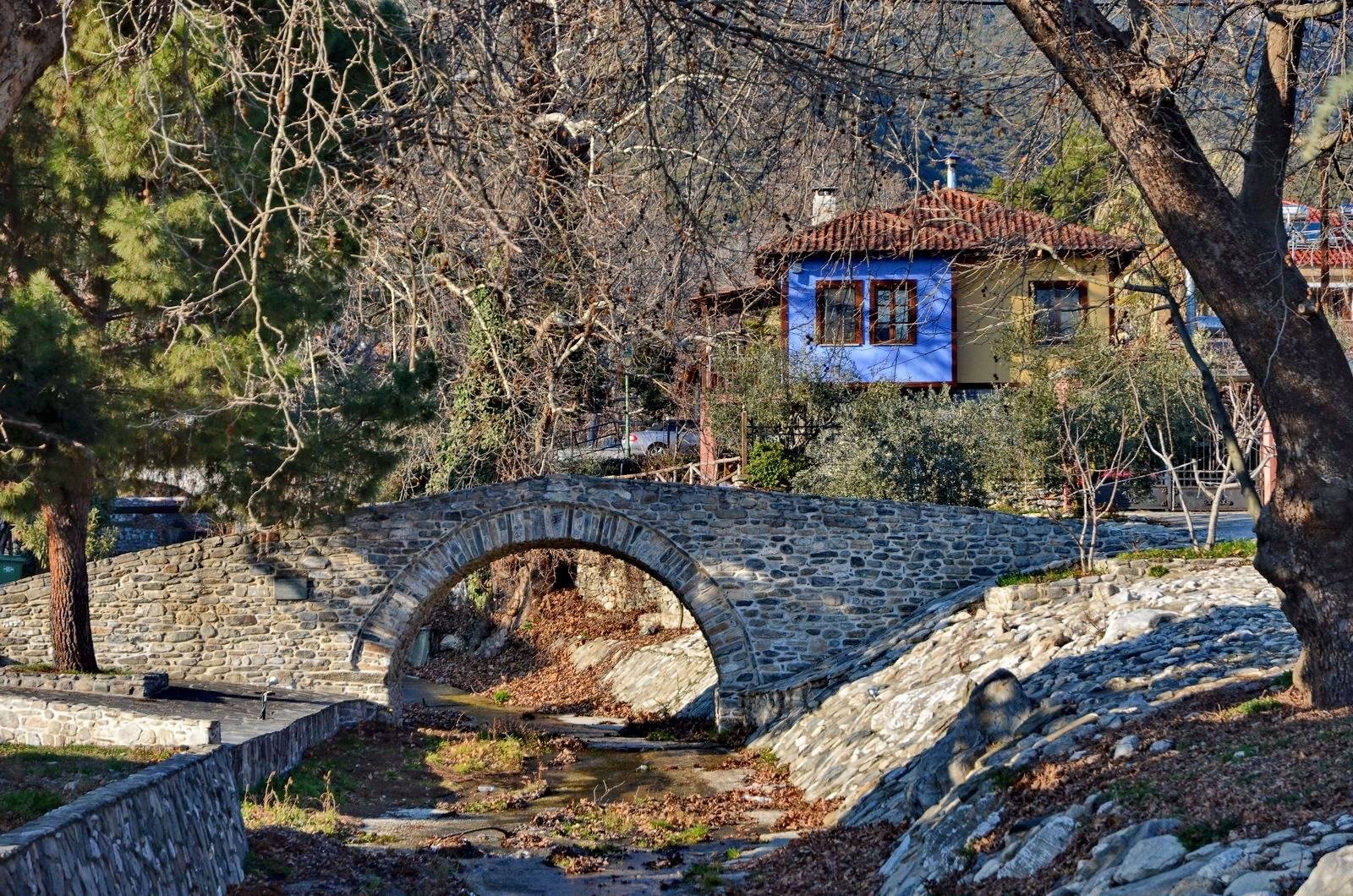 Το πέτρινο γεφύρι των Δωματίων, με παραδοσιακό σπίτι στο βάθος