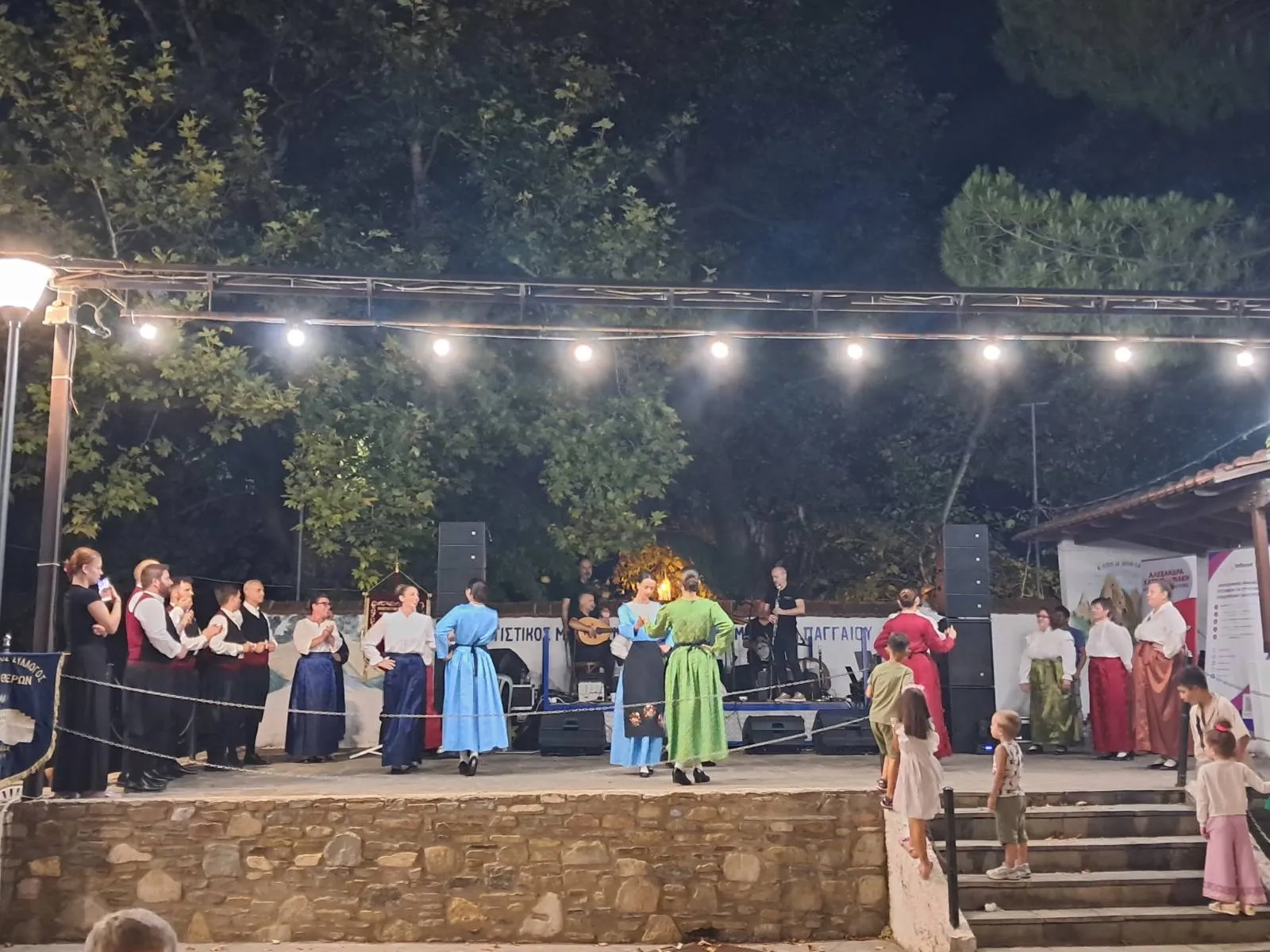 Δύο χορεύτριες με παραδοσιακές στολές χορεύουν μπροστά στη σκηνή
